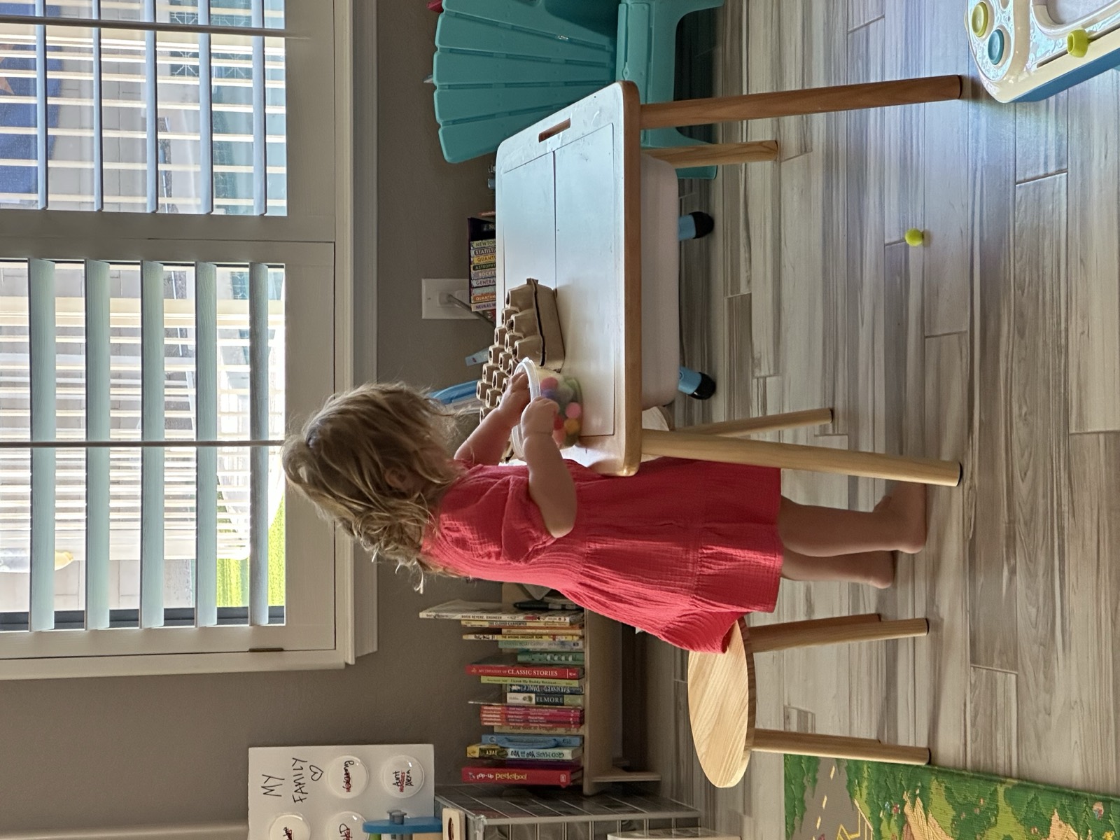 A toddler happily engaged in a Morning Coffee Guide activity at the kitchen table