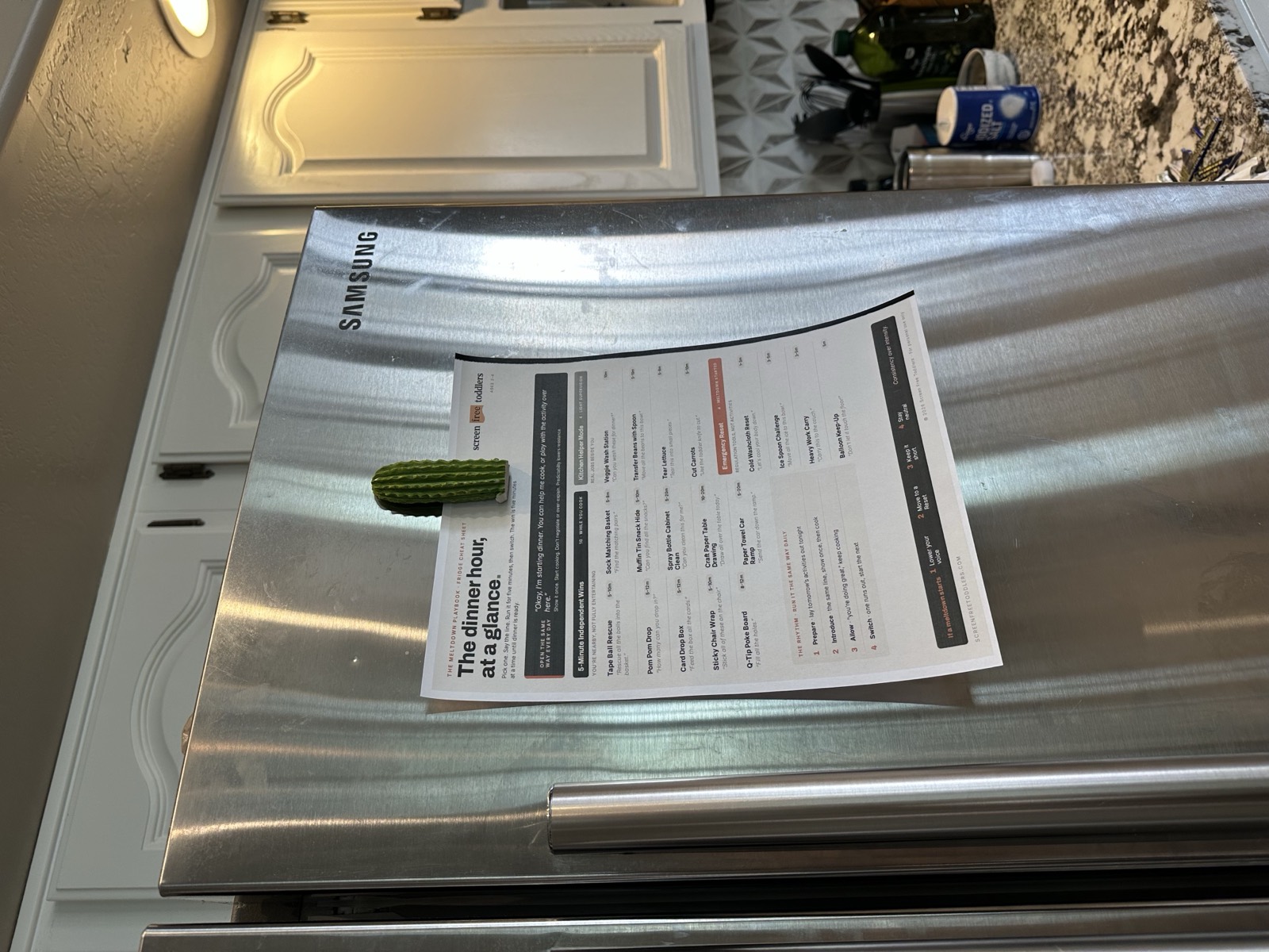 The printable Meltdown Playbook cheat sheet held on a refrigerator door