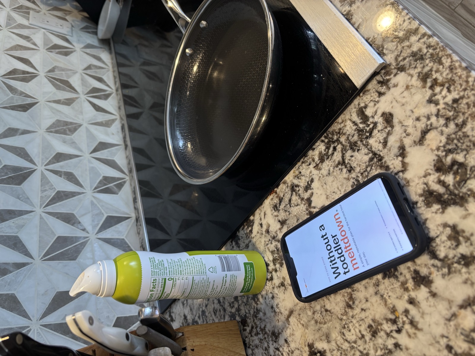 The Meltdown Playbook PDF open on a phone, held in one hand in the kitchen